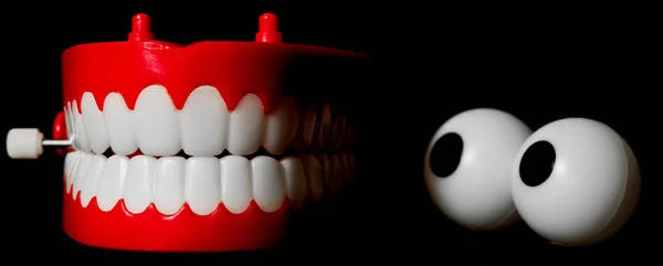 Tjattrande tänder leksak tittar på sig själv Royaltyfria Stockbilder