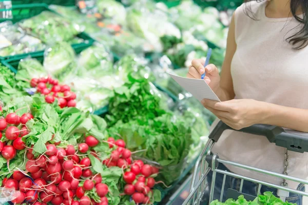 alışveriş listesini kontrol ediyor 