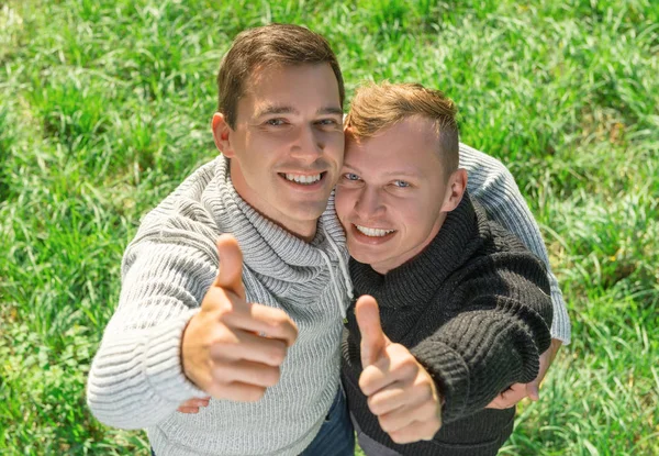 Jovem gay casal dando polegares até — Fotografia de Stock