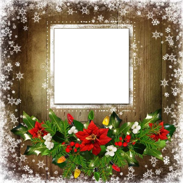 Fondo de felicitación de Navidad con tarjeta, ramas de pino, poinsettia, ramas de bayas, luces de guirnalda sobre un fondo de madera — Foto de Stock