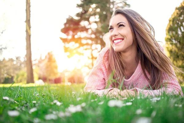 Ursnygg ung kvinna liggande på gräset — Stockfoto