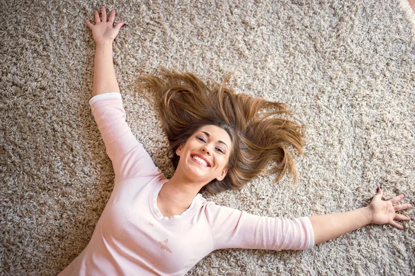 Bella donna felice che si trova su un tappeto — Foto Stock