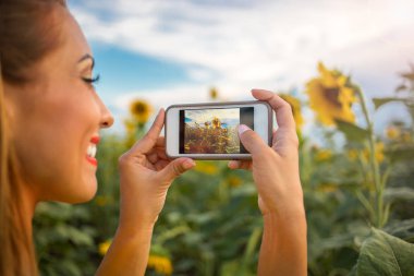 Güzel genç kadın bir ayçiçeği bir resim çekmek