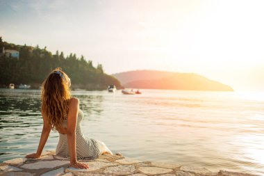Gün batımını denizde güzel genç kadının