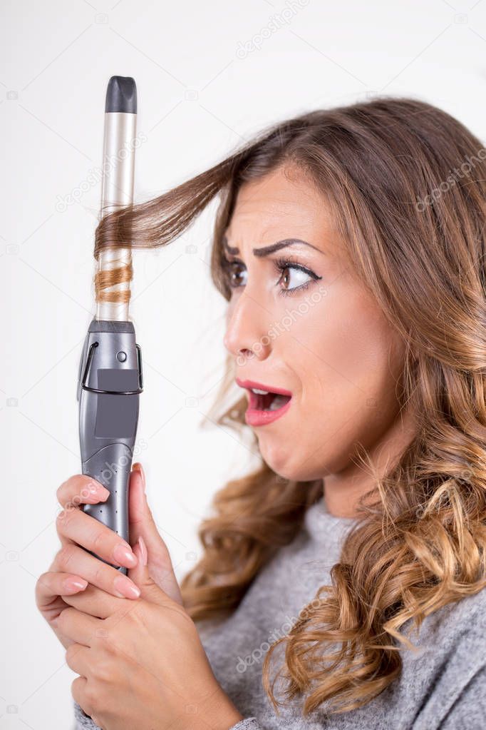 Beautiful woman with curling iron