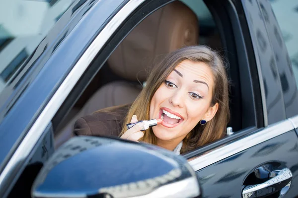 Wanita cantik memakai lipstik di mobil — Stok Foto