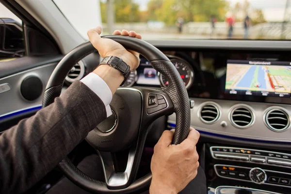 Closeup of man driving a car holding steering wheel — Stock Photo, Image