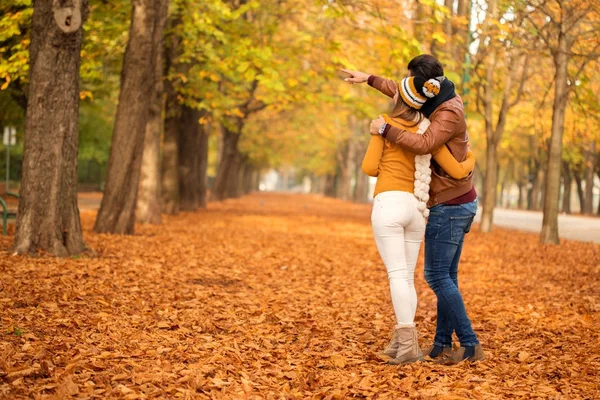 Glückliches Paar spaziert durch einen Park und schaut sich etwas an — Stockfoto