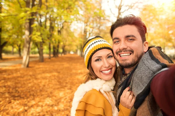 Güzel çift bir selfie bir parkta sonbaharda alarak. — Stok fotoğraf
