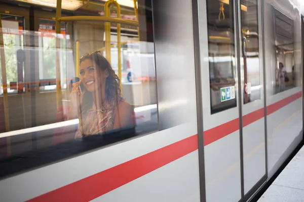 Piękna młoda kobieta siedzi w metrze, podczas gdy fotografowane fro — Zdjęcie stockowe