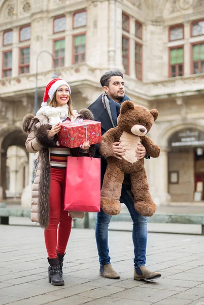 Mooie paar lopen op een straat met Kerst presenteert — Stockfoto