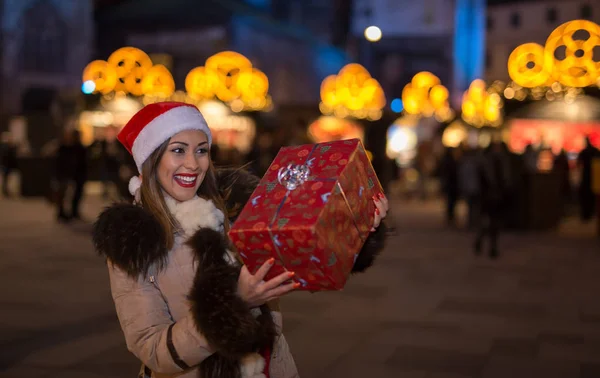 Mooie vrouw met kerstcadeau 's nachts — Stockfoto