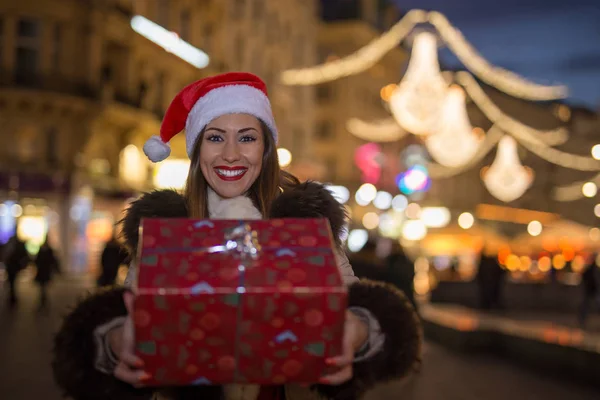 Mooie vrouw met kerstcadeau 's nachts — Stockfoto