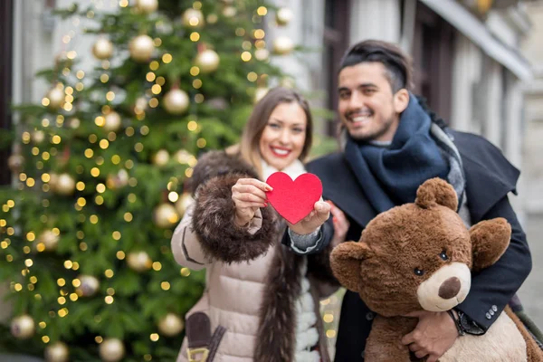 Wazig gelukkige paar voor Valentines day holding een hart en een ted — Stockfoto