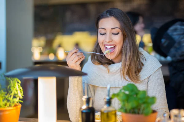 Piękna kobieta, jeść obiad w restauracji, jednocześnie uśmiechając się — Zdjęcie stockowe