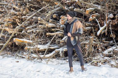 Önünde duran yakışıklı delikanlı odun kar üzerinde kesmek.