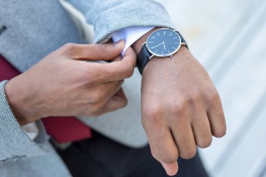 Closeup gömleğini sabitleme bir iş adam saat