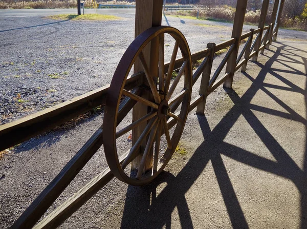 Roue de wagon sur clôture en bois rustique — Photo