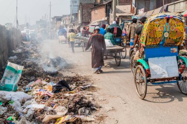 Dhaka, Bangladeş - 22 Kasım 2016: Bangladeş 'in orta kesimindeki Sadarghat-Gabtoli Yolu' nda çöp yığını ve rickshaws