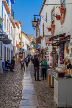 Obidos, Portekiz - 12 Ekim 2017: Portekiz 'in Obidos köyünde dar bir sokakta turistler