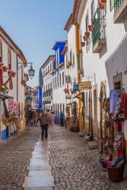 Obidos, Portekiz - 12 Ekim 2017: Portekiz 'in Obidos köyünde dar bir sokakta turistler