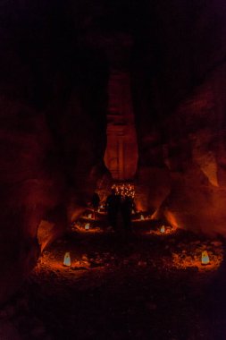 Ürdün 'de Petra boyunca Siq (dar geçit, antik Petra' nın ana girişi) boyunca uzanan mumlar. Arka planda Hazine (Hazine)..