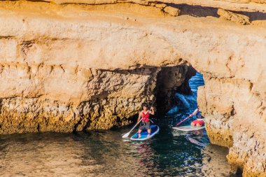 Lagos, Portekiz - 7 Ekim 2017: Lagos, Portekiz yakınlarındaki kayalıklarda stand-up sörfü.