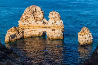 Lagos, Portekiz - 7 Ekim 2017: Lagos, Portekiz yakınlarındaki kayalıklarda stand-up sörfü.