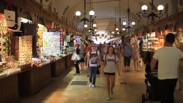 Folk handlar i tyghallen på Salutorget i Krakow, Polen — Stockvideo