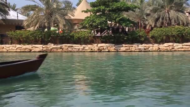 Небольшое туристическое судно, проходящее в районе Мадинат Джумейра в Дубае, ОАЭ — стоковое видео