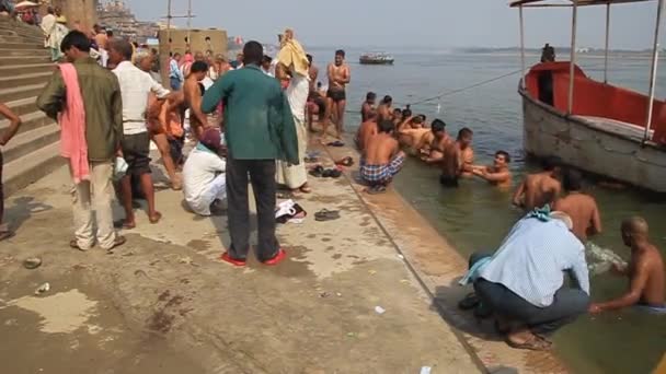 Lokale mensen wassen zich in heilig water van Ganges rover op een Ghat rivier stappen in Varanasi, India — Stockvideo