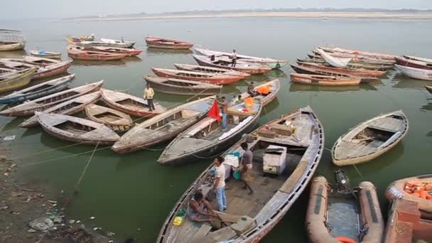 Small boats near Ghats riverfront steps leading to the banks of the River Ganges in Varanasi, India — 비디오