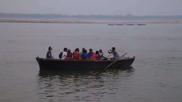 Petit bateau transportant la population locale près des marches du fleuve Ghats menant aux rives du Gange à Varanasi, Inde Vidéo De Stock