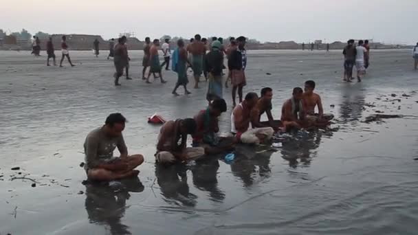 Hinduscy wielbiciele modlą się przed świętym zanurzeniem podczas festiwalu Rash Mela na wyspie Dublar Char Dubla w Bangladeszu. — Wideo stockowe