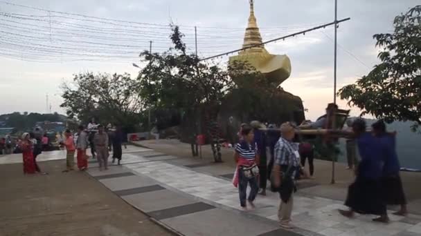 İnsanlar Myanmar 'daki Kyaiktiyo Altın Kayası yakınlarında küçük bir stupanın önünden geçiyorlar. — Stok video