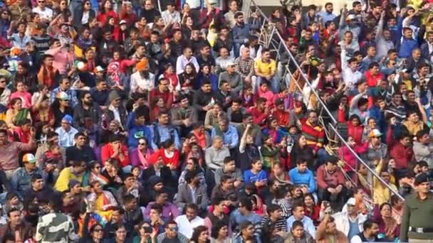 Menigte van Indiase toeschouwers kijken naar de militaire ceremonie bij India-Pakistan grens in Wagah — Stockvideo