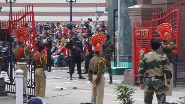 Прикордонні охоронці стежать за індійськими глядачами на військовій церемонії на індійсько-пакистанському кордоні у Вазі. — стокове відео