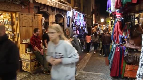 グラナダのCaldereria Nueva通りの様々な屋台に沿って人々が歩く. — ストック動画
