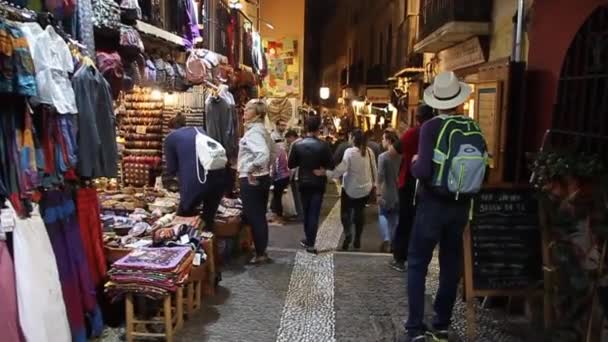 La gente cammina lungo varie bancarelle in via Calle Caldereria Nueva a Granada . — Video Stock