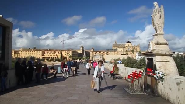 Mensen steken de Romeinse brug van Cordoba over.. — Stockvideo