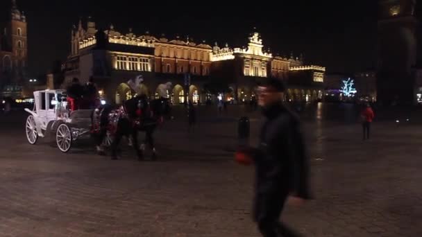 Carruajes tirados a la antigua en la plaza Rynek Glowny en Cracovia, Polonia — Vídeos de Stock