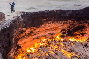 DARVAZA, TURKMENISTAN - 19 Nisan 2018: Türkmenistan 'daki Darvaza (Derweze) gaz kraterinde selfie çeken çift