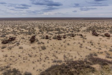 Özbekistan 'ın Aral Denizi' nin eski kıyısındaki Moynaq köyü yakınlarındaki gemi mezarlığında paslanan gemiler.