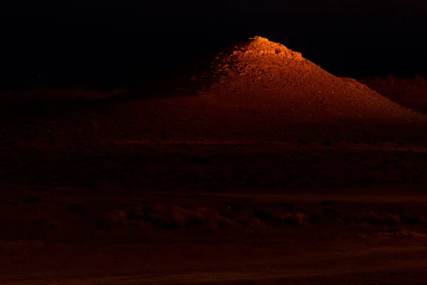 Peak illuminated by the light from Darvaza (Derweze) gas crater (Door to Hell or Gates of Hell) in Turkmenistan