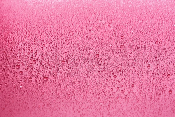 Wassertropfen auf rosa Hintergrund — Stockfoto