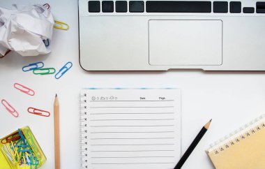 Beyaz ofis büro dizüstü bilgisayar ve diğer aksesuarları en iyi görünümünü; defter kalem ve ataç