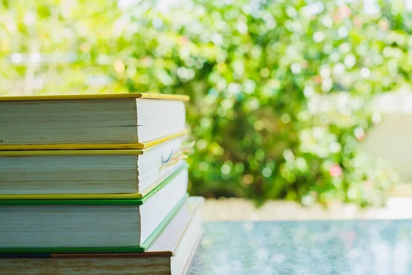 Stapel von Büchern mit verschwommenem natürlichen Hintergrund — Stockfoto