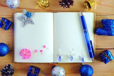 Boş günlük defter ile Noel ve yılbaşı süsleri ve dekorasyon ahşap masa, mavi renk teması üzerinde Üstten Görünüm