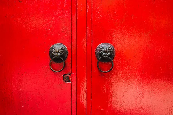 Porta de madeira vermelha velha e batedor da cabeça do leão — Fotografia de Stock