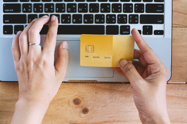 Верхний вид руки, держащей кредитную карту и ввод данных в компьютер ноутбук для бизнеса и финансовой концепции
